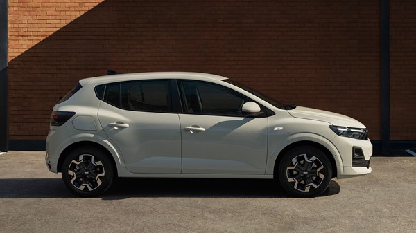 Dacia Sandero во Sandstone Beige фотографирана од страна пред фасада од тули.