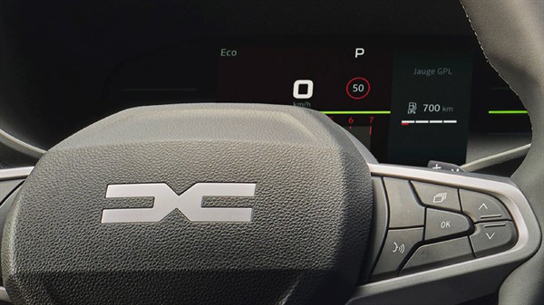 Поглед на 7-инчниот дигитален инструмент дисплеј во Dacia Sandero, снимен од зад управувачот.