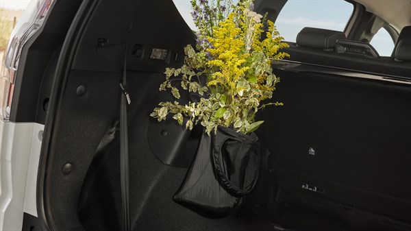 Торба со капак YouClip прикачена на багажниот простор на Dacia Sandero Stepway, исполнета со цветни гранчиња.