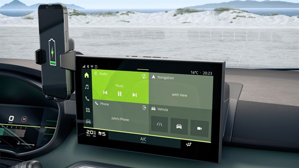 Паметен телефон поставен на индуктивниот безжичен полнач YouClip во кабината на Dacia Sandero Stepway, со прикажан централен мултимедијален екран.