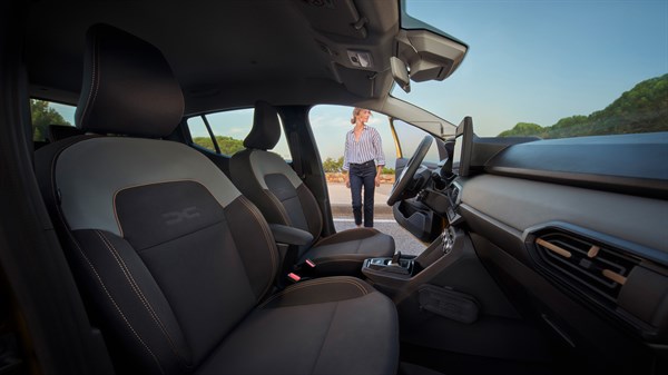 Внатрешност на Dacia Sandero со  perivim Microcloud навлака и подигната возачка положба, фотографирана од напред кон патничкиот простор.