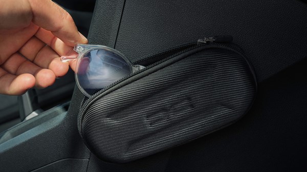 Внатрешноста на Dacia Sandero Stepway прикажува рака како става очила за сонце во преградата за складирање до седиштето.