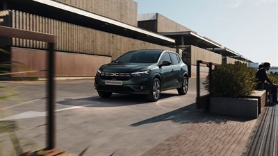 Возило Dacia Sandero Journey паркирано пред модерна зграда во урбана средина.